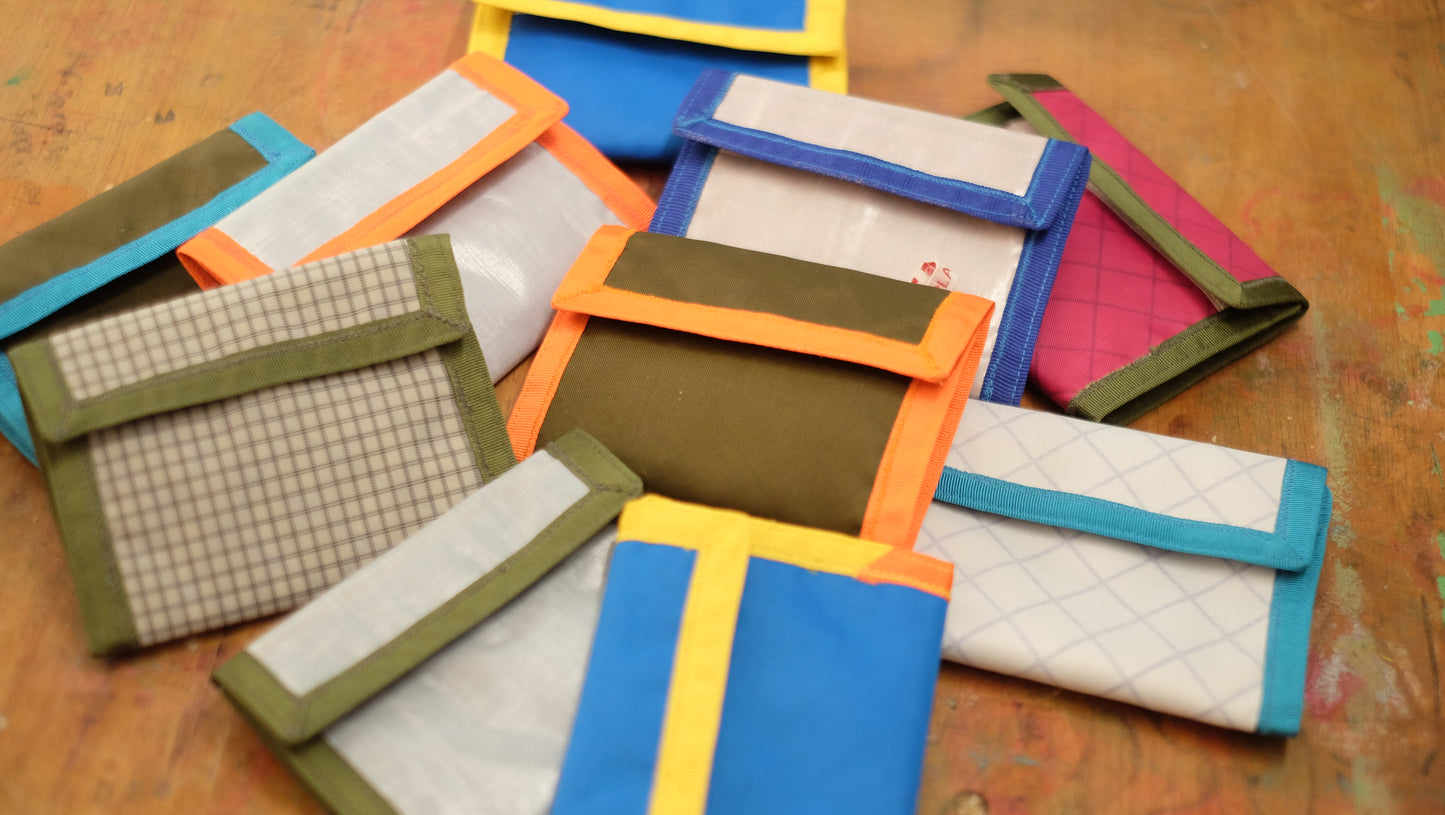 About ten wallets in different colours, closed