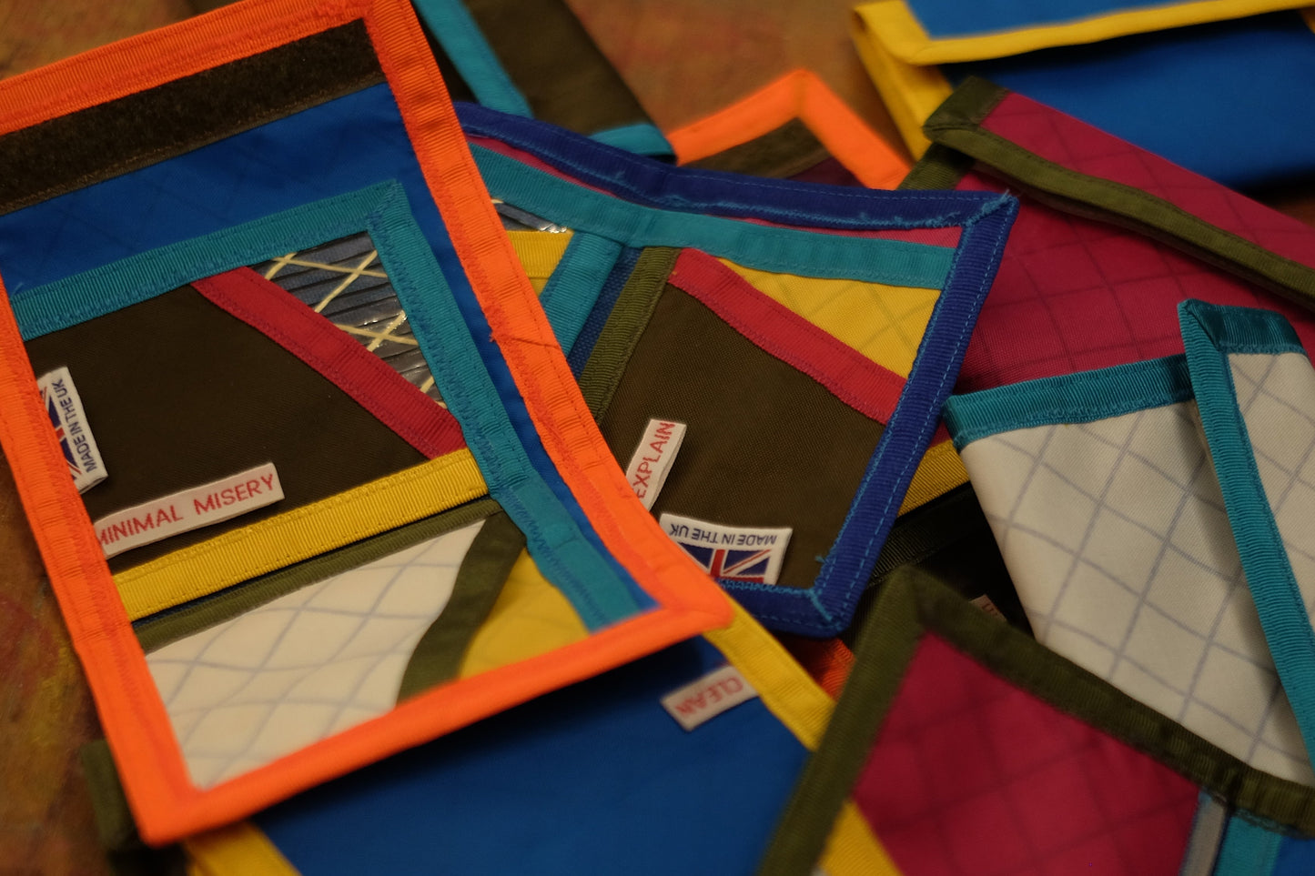 About 10 trifold wallets in bright colours, some open, some closed