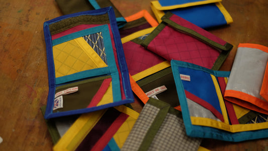 About 10 trifold wallets in different colours